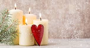 Four standing white candles and one red heart with a side of evergreen